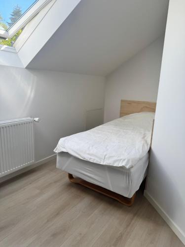 a white bedroom with a bed and a skylight at Vognstrupgaard in Silkeborg