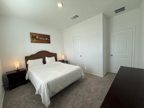 une chambre blanche avec un lit et deux tables de nuit dans l'établissement Cozy Magnolia 4BR 3BA Family Home Retreat, à Magnolia