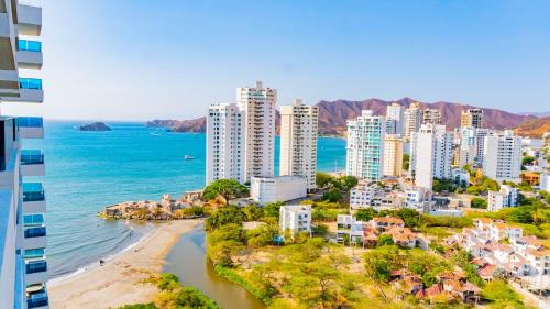 an aerial view of a city with a beach and buildings at Reserva Del Mar Apartamentos in Gaira