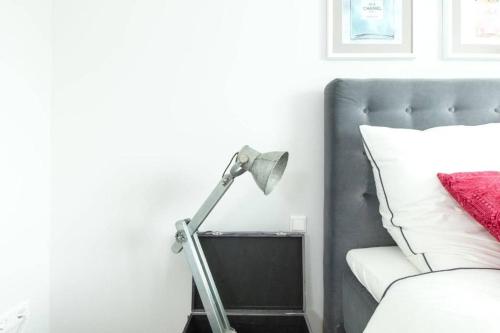 a lamp in a bedroom next to a bed at ChillingHouse Apartments Siegburg in Siegburg