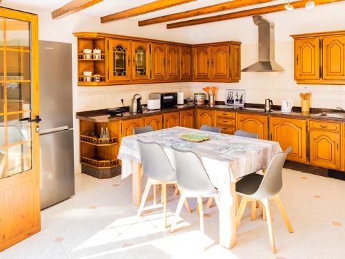 eine Küche mit Holzschränken und einem Tisch und Stühlen in der Unterkunft Live Caletillas Taunus pool in Punta Larga