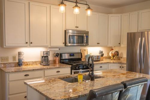 a kitchen with white cabinets and a granite counter top at Downtown West Jefferson Home - Fireplace - Sleeps 8 in West Jefferson