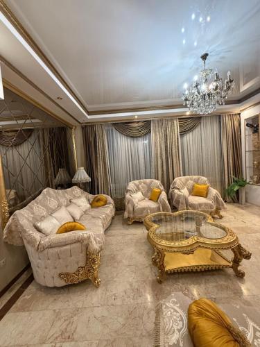 a living room with two couches and a chandelier at Квартира в центре тбилиси in Tbilisi City