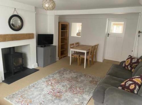 a living room with a couch and a fireplace at Bimble Cottage-2 beds-Gorgeous Sunny Garden in Topsham