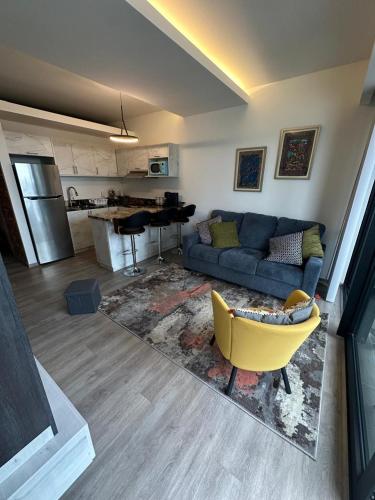 a living room with a blue couch and a yellow chair at Adamant Toreo in Tijuana