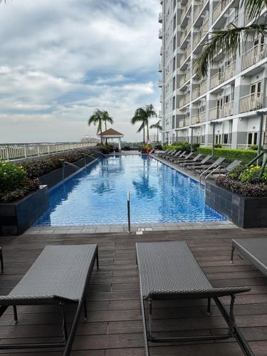 马尼拉Coast Residence 4026 PENTHOUSE 1 Bedroom Condo with Wifi & Netflix的建筑物旁边的一个大型游泳池