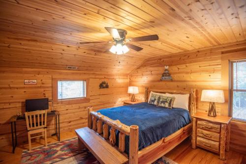 a bedroom with a bed in a log cabin at Adventure Cabin! Fire Pit, State Park, Fishing, Mtn Views, Hot Tub, WiFi in Jefferson