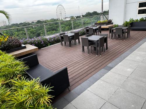 马尼拉Coast Residence 4026 PENTHOUSE 1 Bedroom Condo with Wifi & Netflix的大楼顶部的甲板上配有桌椅