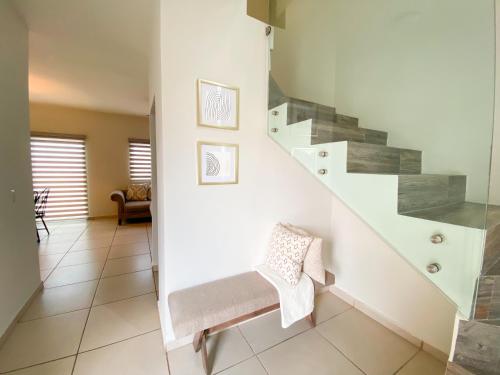 a staircase in a living room with a bench at Casa Moderna en privada con Alberca 5 min del Aeropuerto y Consulado Americano in Hermosillo