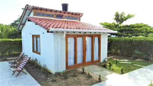 a small tiny house with a tiled roof at Cabaña Maria José in Moñitos
