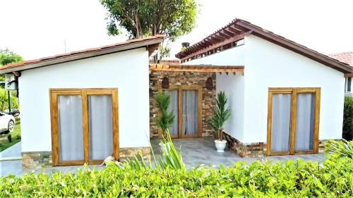 a white house with wooden windows at Cabaña Maria José in Moñitos