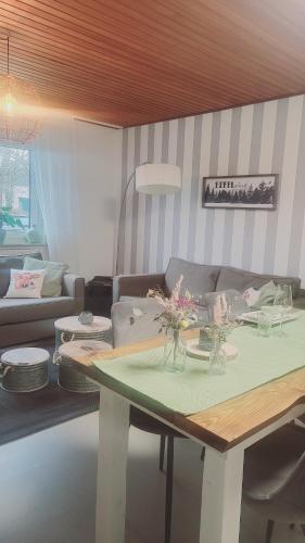 a living room with a couch and a table at Eifelraum-Relaxwohnung in Oberbettingen
