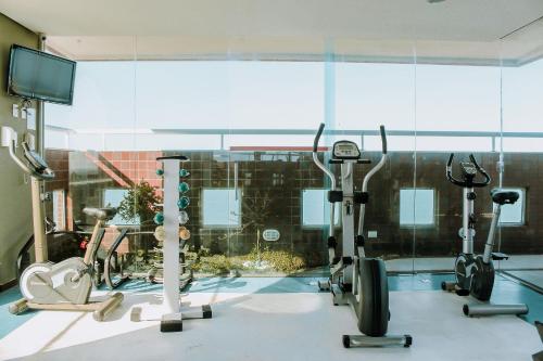 a gym with treadmills and exercise bikes in a room at Interatlântico by Qavi in Natal