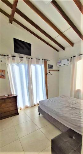 a bedroom with a bed in a room with windows at Cabaña Maria José in Moñitos