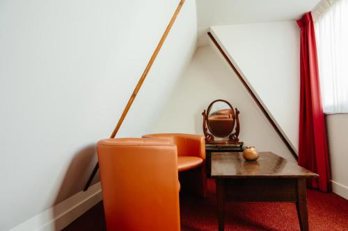 a room with a chair and a table with a bag at Ambassador City Centre Hotel in Haarlem