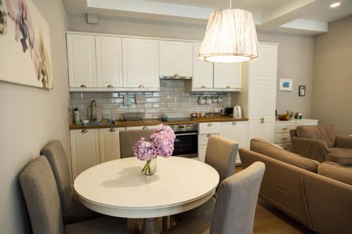 a kitchen and a table with a vase of flowers on it at Miracle Apartment Hotel in Baku