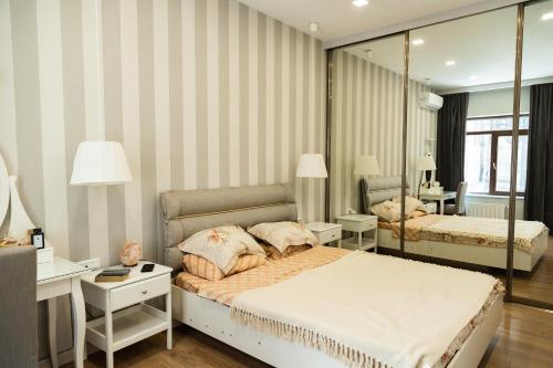 a bedroom with two beds and a mirror at Miracle Apartment Hotel in Baku