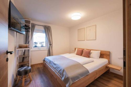 a bedroom with a large bed and a television at Haus Bacher in Fulpmes