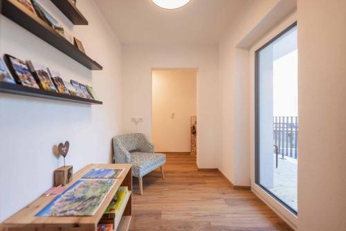 a living room with a table and a chair and a window at Haus Bacher in Fulpmes
