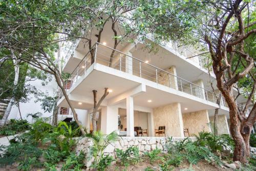 a large white building with trees in the foreground at Corrales Bay Resort in Corrales