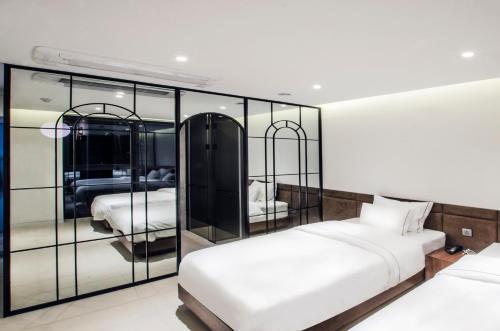 a bedroom with two beds and a mirrored wall at Hotel the Castle Jamsil#1 in Seoul