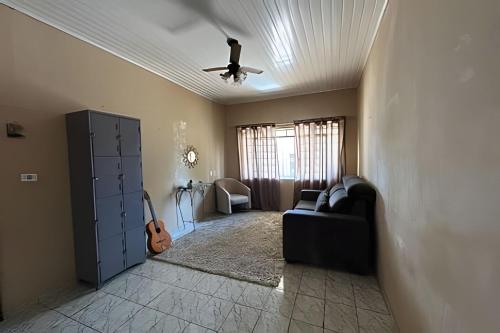 a living room with a ceiling fan and a couch at Casa confortável na região da Vila Universitária em Bauru in Bauru