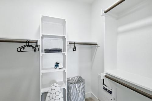 a bathroom with white walls and white shelves at 101 Stylish Condo, Resort Amenities, Near Stockyards in Fort Worth