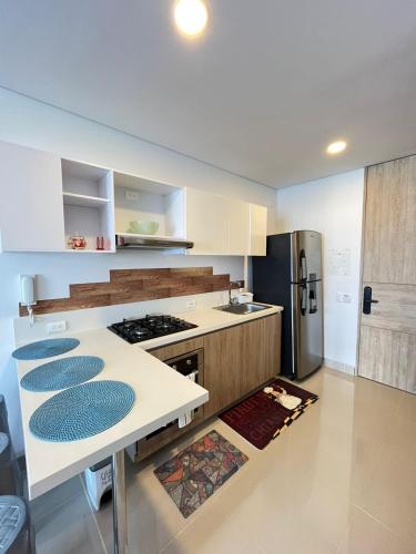 a kitchen with a stove and a refrigerator at Reserva Del Mar Apartamentos in Gaira