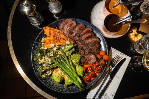 a plate of food with meat and vegetables on a table at Ambassador City Centre Hotel in Haarlem