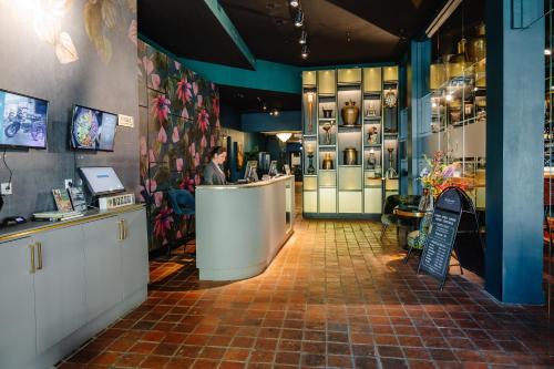 a man is standing at a counter in a restaurant at Ambassador City Centre Hotel in Haarlem
