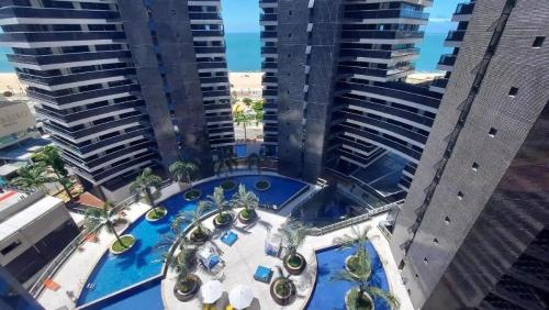 an aerial view of a pool in the middle of two tall buildings at Landscape Beira Mar in Fortaleza