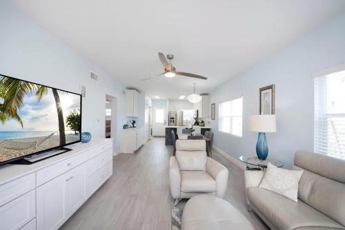 a living room with a couch and a tv at Plantation Village #37 Condo in Seven Mile Beach