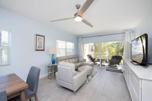 a living room with a couch and a tv and a table at Plantation Village #37 Condo in Seven Mile Beach