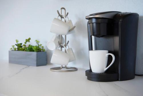 a coffee maker and cups on a counter at Plantation Village #37 Condo in Seven Mile Beach