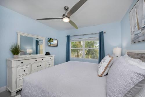 a bedroom with a bed and a dresser and a mirror at Plantation Village #37 Condo in Seven Mile Beach