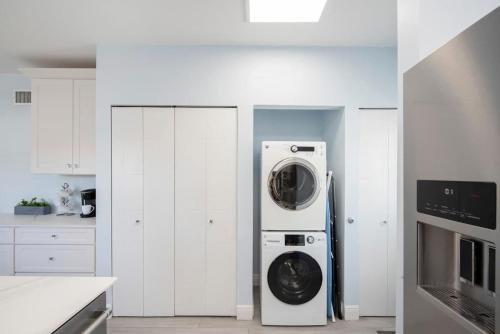 a white kitchen with a washer and dryer in it at Plantation Village #37 Condo in Seven Mile Beach