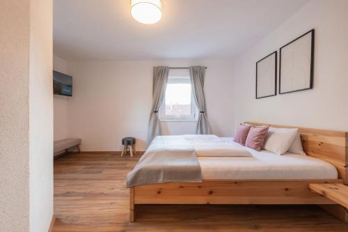 a bedroom with a large wooden bed in front of a window at Haus Bacher in Fulpmes
