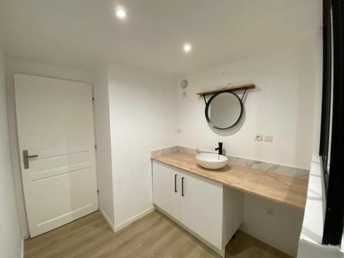 a bathroom with a sink and a mirror on a counter at Petite maison de bourg in Le Bourgneuf-la-Forêt