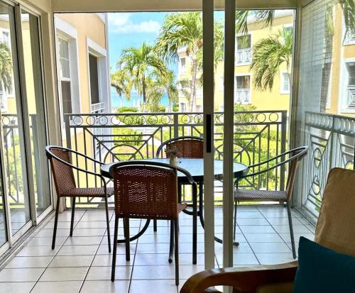 un patio con tavolo e sedie su un balcone di Regal Beach Club #322 a George Town