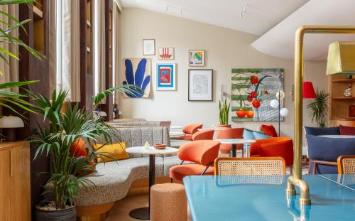 a room with orange and blue chairs and plants at Club Quarters Hotel St Paul's, London in London