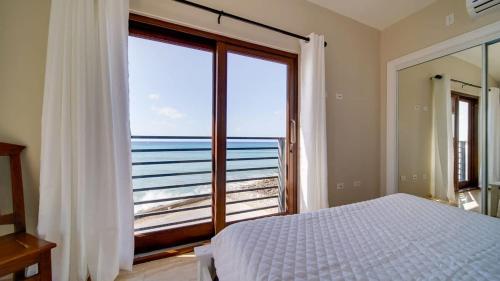 a bedroom with a large window with a view of the ocean at Seven Mile View Condo #1 in West Bay