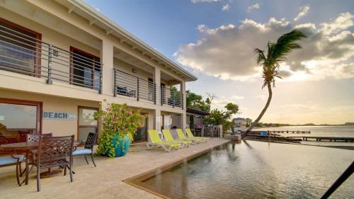 a house with a swimming pool and a palm tree at Seven Mile View Condo #1 in West Bay