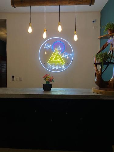a bar with a neon sign on a wall at Hotel luz de luna in Mahahual