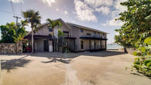 a large white house with a palm tree and the ocean at Seven Mile View Condo #1 in West Bay