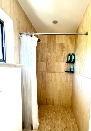 a shower with a white shower curtain in a bathroom at Seven Mile View Condo #1 in West Bay
