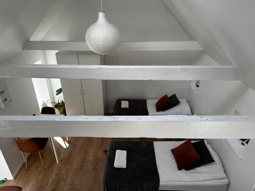 twolevels of a loft with two beds in a room at Ebogaard in Hillerød