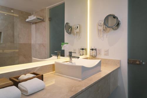 a bathroom with a sink and a mirror at Flamingo Cancun All Inclusive in Cancún