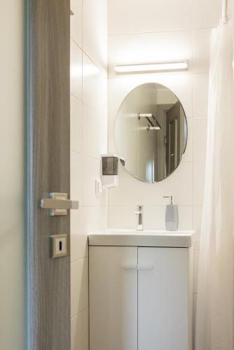 a white bathroom with a sink and a mirror at Seren Natura Retreat in Sebeşu de Sus