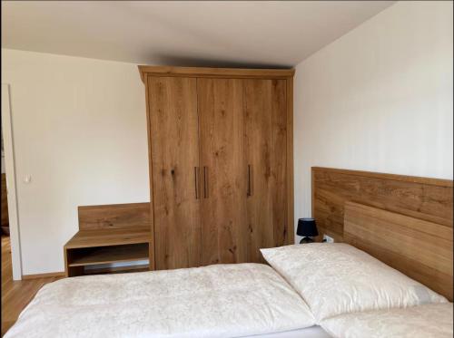 a bedroom with a bed and a wooden cabinet at Ruhe und Komfort bei TinyHouseAnna in Sankt Nikolai ob Draßling