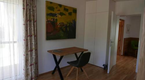 a table and a chair in a room with a painting at Ruhe und Komfort bei TinyHouseAnna in Sankt Nikolai ob Draßling